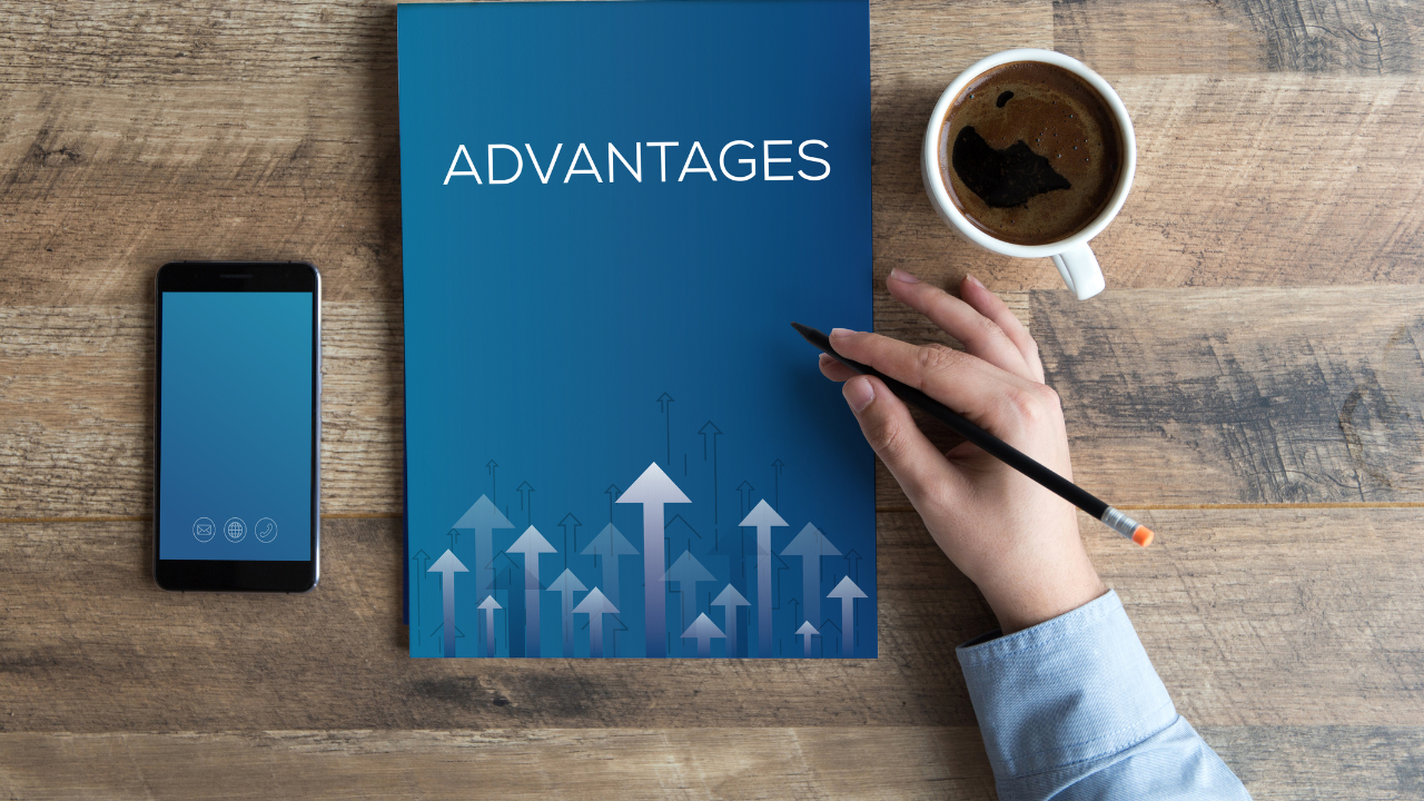 Notebook with the title 'Advantages' on a wooden desk, accompanied by a smartphone and coffee cup, representing business benefits and planning.